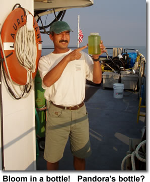 Dr. Bopi Biddanda holds a bottle with water from an algal bloom in Lake Erie in 2003